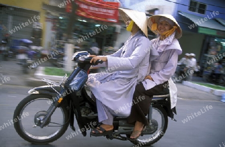 Frauen Moenche auf einem Motorrad im Stadtzentrum von Ho Chi Minh City oder Saigon im sueden von Vietnam in Suedostasien.  