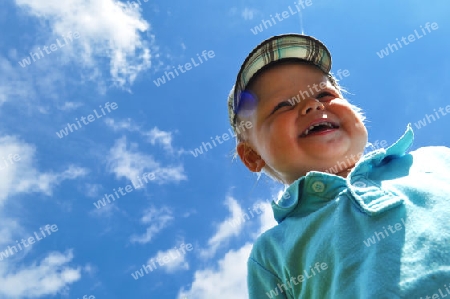 Little boy walking through the fields in summer