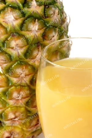 Ananassaft mit einer frischen Ananas im Hintergrund