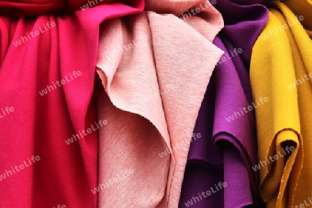 Detailed close up view on samples of cloth and fabrics in different colors found at a fabrics market.