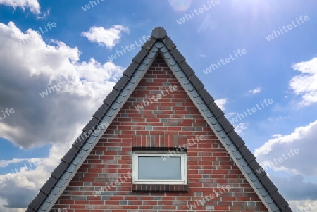 Roof window in velux style with dark roof tiles