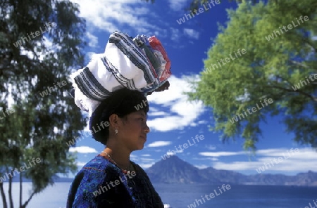 People at the coast of Lake Atitlan mit the Volcanos of Toliman and San Pedro in the back at the Town of Panajachel in Guatemala in central America.   