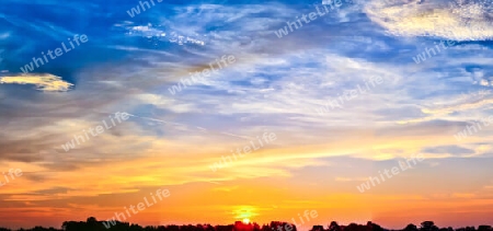 Beautiful high resolution panorama of orange and red sunset clouds in the evening sky.