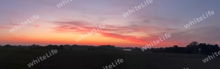 Beautiful high resolution panorama of a northern european country landscape with fields and green grass.