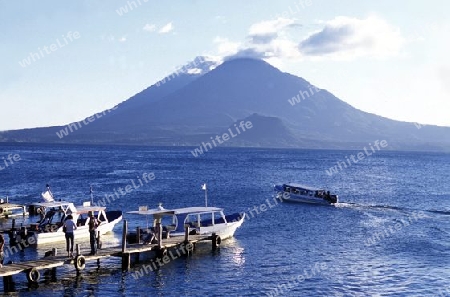 The Lake Atitlan mit the Volcanos of Toliman and San Pedro in the back at the Town of Panajachel in Guatemala in central America.   