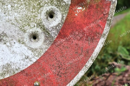 Detailed close up of bullet holes from gun shots in a german traffic sign