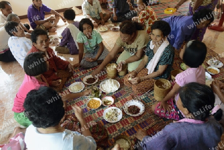 Menschen geniessen das Essen bei einem Familiaeren Fest in der Umgebung von Ubon Ratchathani im nordosten von Thailand in Suedostasien.