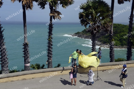 Ein Hochzeitspaar bei einem Fototermin am Aussichtspunkt Kap Promthep bei der Rawai Beach im sueden der Insel Phuket im sueden von Thailand in Suedostasien.