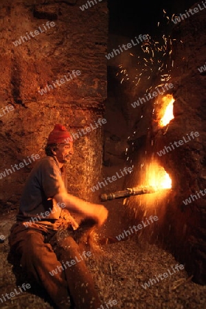 A men heat up Water for a Hammam or Arab Bath in the old City in the historical Town of Fes in Morocco in north Africa.