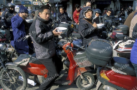 people eat a noodle soupe in the trafic line in the City of Shanghai in china in east asia. 