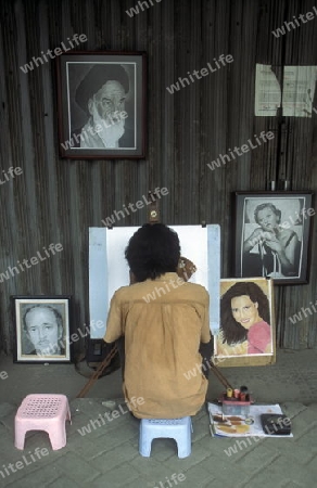 artist painter at working in a shop in the city centre of Jakarta in Indonesia in Southeastasia.