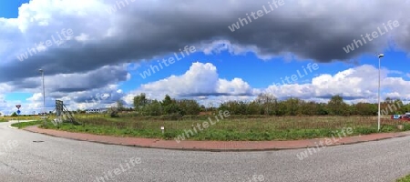 Beautiful high resolution panorama of a northern european country landscape with fields and green grass.