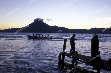 People at the coast of Lake Atitlan mit the Volcanos of Toliman and San Pedro in the back at the Town of Panajachel in Guatemala in central America.   