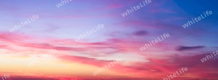 Beautiful high resolution panorama of orange and red sunset clouds in the evening sky.