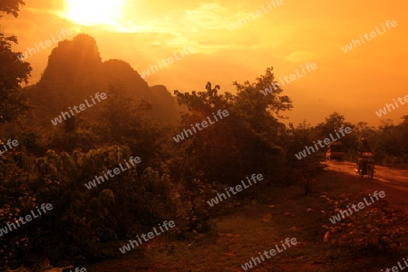 Die Huegellandschaft an der Landstrasse 12 zwischen der Stadt Tha Khaek und dem Dorf Mahaxai Mai in zentral Laos an der Grenze zu Thailand in Suedostasien.