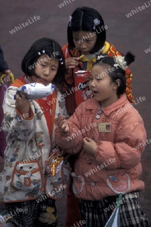 childern with some snaks on the streets of Chongqing in the province of Sichuan in china in east asia. 