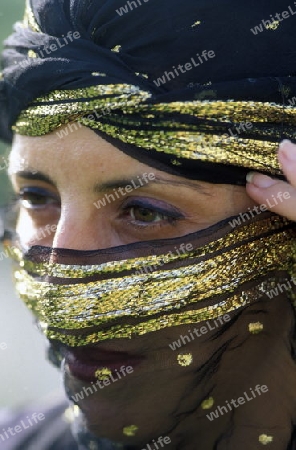 Eine Tunesische Frau in traditionellem Kopftuch  in Monastir am Mittelmeer im Nordosten von Tunesien in Nordafrika.