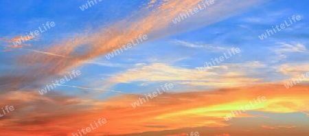 Beautiful high resolution panorama of orange and red sunset clouds in the evening sky.