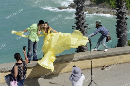 Ein Hochzeitspaar bei einem Fototermin am Aussichtspunkt Kap Promthep bei der Rawai Beach im sueden der Insel Phuket im sueden von Thailand in Suedostasien.