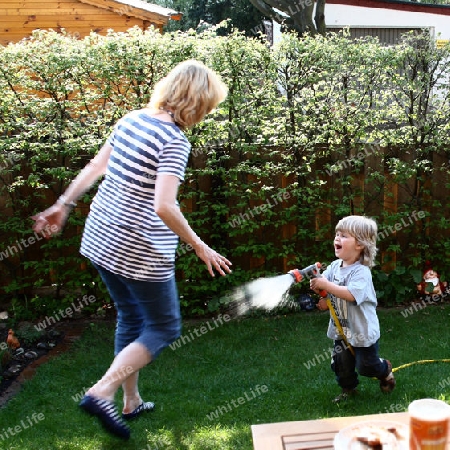 Kind spritzt Frau mit Wasser nass3