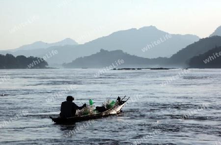 Ein Fischerboot auf dem Mekong River bei Luang Prabang in Zentrallaos von Laos in Suedostasien.