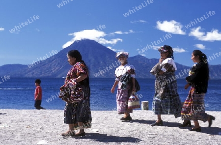 People at the coast of Lake Atitlan mit the Volcanos of Toliman and San Pedro in the back at the Town of Panajachel in Guatemala in central America.   