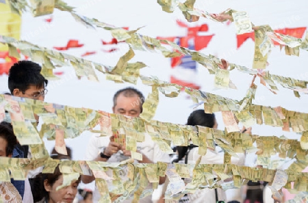 Menschen bei einer Zeremonie mit Geldscheinen in der Tempelanlage des Goldenen Berg in der Hauptstadt Bangkok von Thailand in Suedostasien.