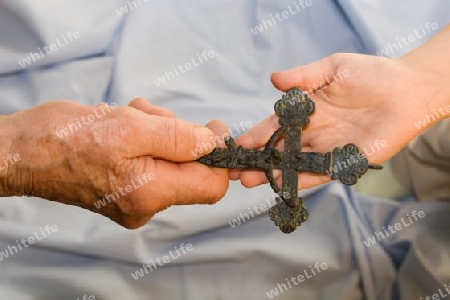 Hand der Grossmutter und der Enkeltochter mit dem Kreuz