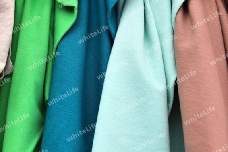 Detailed close up view on samples of cloth and fabrics in different colors found at a fabrics market.