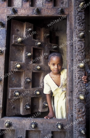 Eine Holztuer in der Altstadt in Stone Town der Hauptstadt der Insel Zanzibar im Indischen Ozean in Tansania in Afrika.