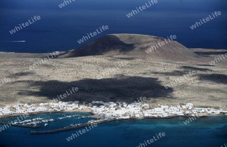 The  Isla Graciosa with the village of Caleta del Sebothe from the Mirador del Rio viewpoint on the Island of Lanzarote on the Canary Islands of Spain in the Atlantic Ocean. on the Island of Lanzarote on the Canary Islands of Spain in the Atlantic Oc