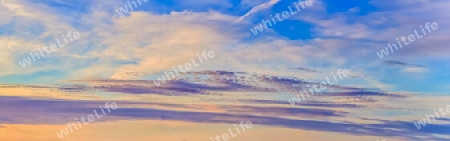 Beautiful high resolution panorama of orange and red sunset clouds in the evening sky.