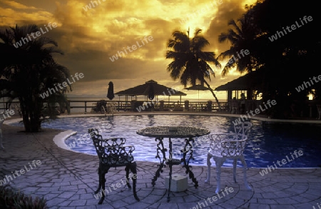 Ein Hotelstrand mit Pavillon bei Sonnenuntergang auf der Insel Praslin auf den Seychellen im Indischen Ozean.