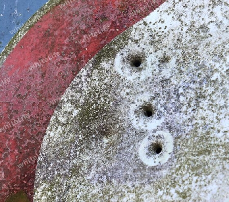 Detailed close up of bullet holes from gun shots in a german traffic sign