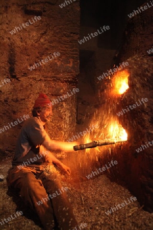 A men heat up Water for a Hammam or Arab Bath in the old City in the historical Town of Fes in Morocco in north Africa.