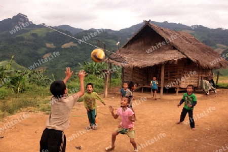 Kinder beim Fussball Spielen in einem Bergdorf in der Bergregion beim Dorf Kasi an der Nationalstrasse 13 zwischen Vang Vieng und Luang Prabang in Zentrallaos von Laos in Suedostasien. 