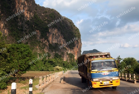 Die Landstrasse 12 beim Dorf Mahaxai Mai von Tham Pa Fa unweit der Stadt Tha Khaek in zentral Laos an der Grenze zu Thailand in Suedostasien.