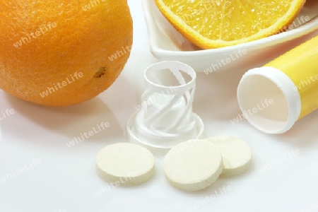 Orange mit Brausetabletten auf hellem Hintergrund