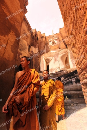 Moenche bestaunen die Buddha Figur  im Wat Si Chum Tempel in der Tempelanlage von Alt-Sukhothai in der Provinz Sukhothai im Norden von Thailand in Suedostasien.