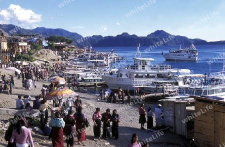 People at the coast of Lake Atitlan mit the Volcanos of Toliman and San Pedro in the back at the Town of Panajachel in Guatemala in central America.   