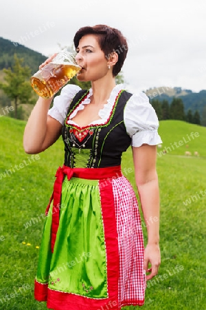 Sch?ne M?dchen im Dirndl trinkt Bier