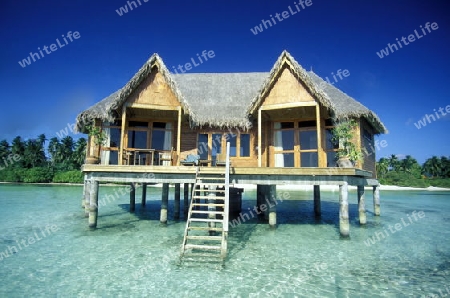 Ein Bungalow am Traumstrand auf einer Touristen Insel auf dem Malediven im Indischen Ozean.