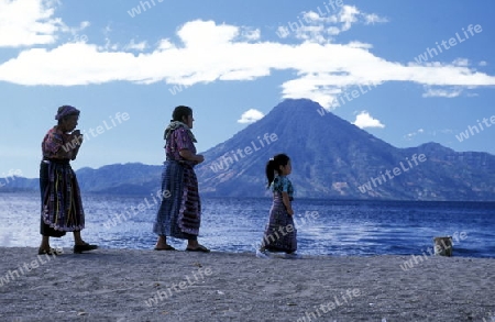 People at the coast of Lake Atitlan mit the Volcanos of Toliman and San Pedro in the back at the Town of Panajachel in Guatemala in central America.   