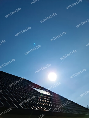 Open roof window in velux style with black roof tiles