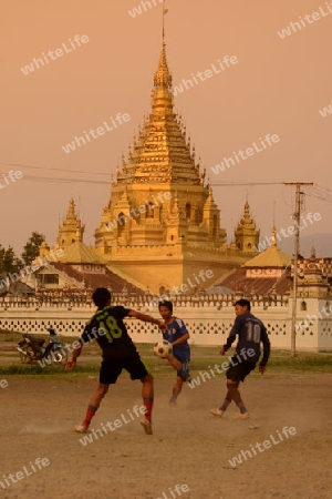 soccer player in soccer field in front of the Yadana Man Aung Pagoda in the town of Nyaungshwe at the Inle Lake in the Shan State in the east of Myanmar in Southeastasia.