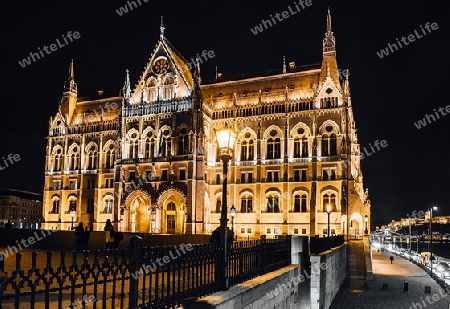 The Hungarian Parliament in Budapest on the Danube in the night lights of the street lamps