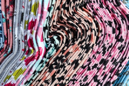 Detailed close up view on samples of cloth and fabrics in different colors found at a fabrics market.