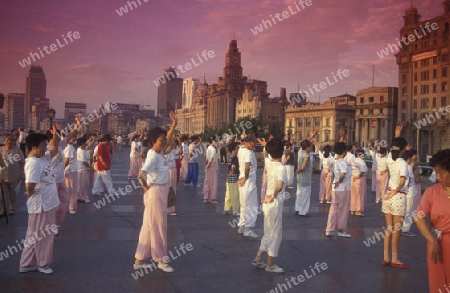 people dancing in the morning on the Bund in front of the skyline of Pudong in the City Shanghai in China.