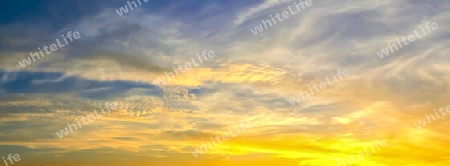 Beautiful high resolution panorama of orange and red sunset clouds in the evening sky.