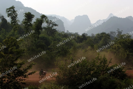 Die Huegellandschaft an der Landstrasse 12 zwischen der Stadt Tha Khaek und dem Dorf Mahaxai Mai in zentral Laos an der Grenze zu Thailand in Suedostasien.